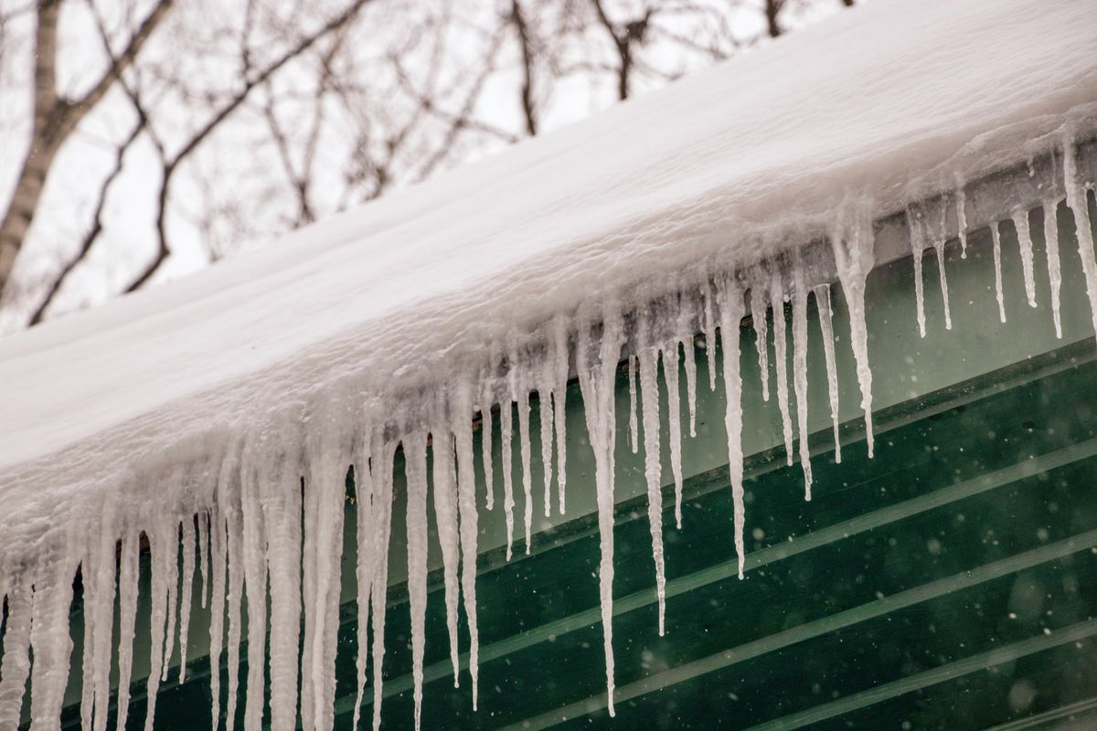 Glaçons accumulés sur une gouttière de toiture après une tempête